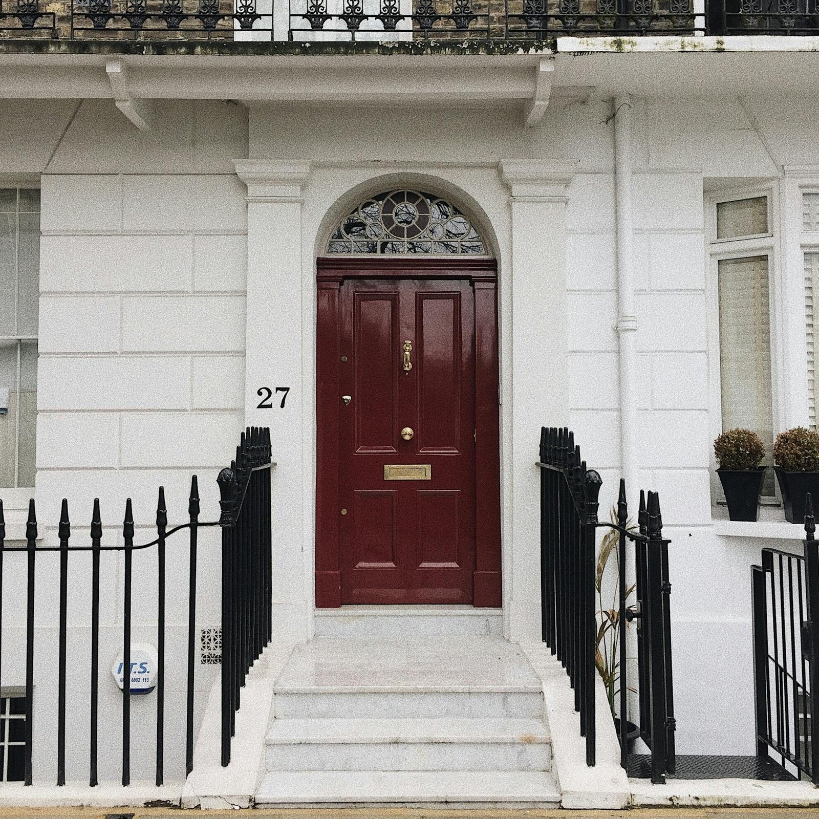 Classic Georgian-style doorway with red door in London, UK.